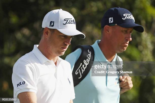 Justin Thomas of the United States walks with caddie Jim "Bones" Mackay during practice rounds prior to the Sony Open In Hawaii at Waialae Country...