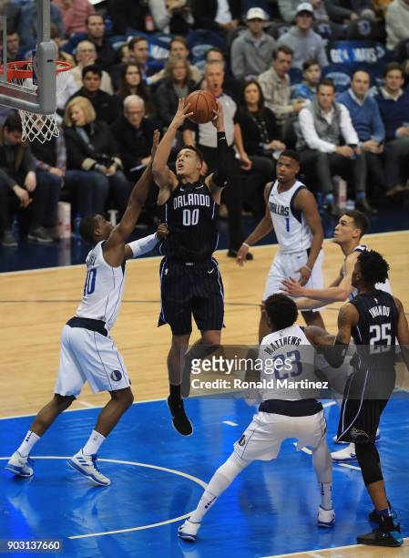 Aaron Gordon of the Orlando Magic takes a shot against Harrison Barnes of the Dallas Mavericks in the first half at American Airlines Center on...