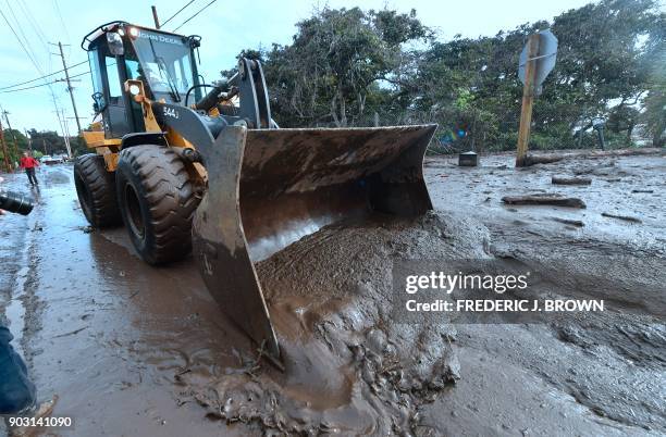 Bulldozer clears mud off the road near a flooded section of US 101 freeway near the San Ysidro exit in Montecito, California on January 9, 2018....