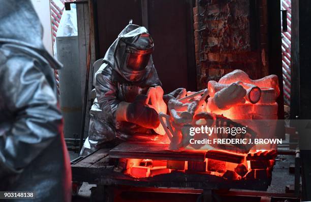 Workers at the American Fine Arts Foundry pour hot molten bronze into molds on January 9, 2018 in Burbank, California to make the solid bronze...
