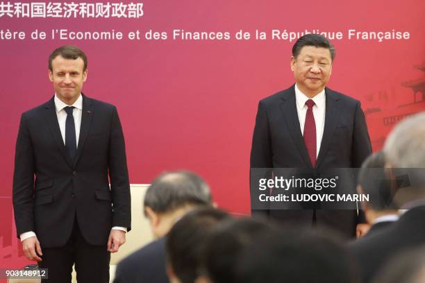 French President Emmanuel Macron and Chinese President Xi Jinping stand to inaugurate the first meeting of the French-Chinese business council in...