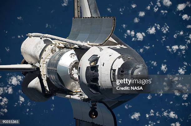 In this handout image from NASA taken by the International Space Station crew, the Space Shuttle Discovery performs a 360 degree flip August 30, 2009...