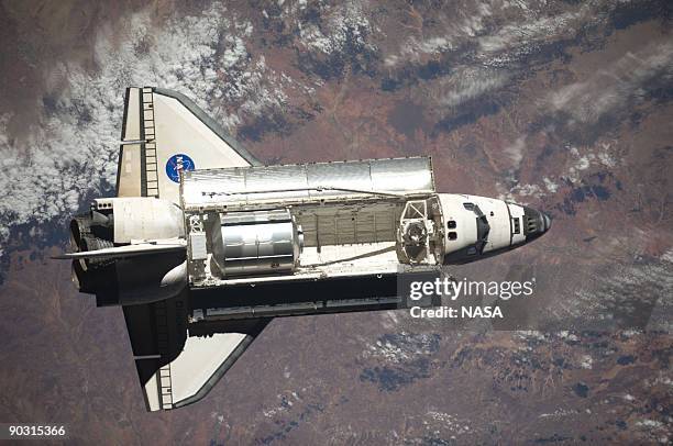In this handout image from NASA taken by the International Space Station crew, the Space Shuttle Discovery performns rendezvous and docking...