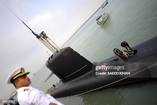 Naval officer watches the French-made Malaysia's first submarine dock at its Naval base in Port Klang on the outskirts of Kuala Lumpur on September...
