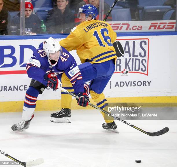 Max Jones of United States plays the puck behind Linus Lindström of Sweden who was defending the play during the first period of play in the IIHF...