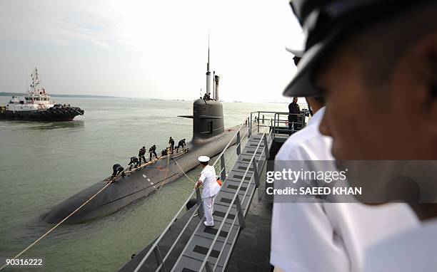 Marines watch as French-made Malaysia's first submarine prepares to dock at its Naval base in Port Klang on the outskirts of Kuala Lumpur on...