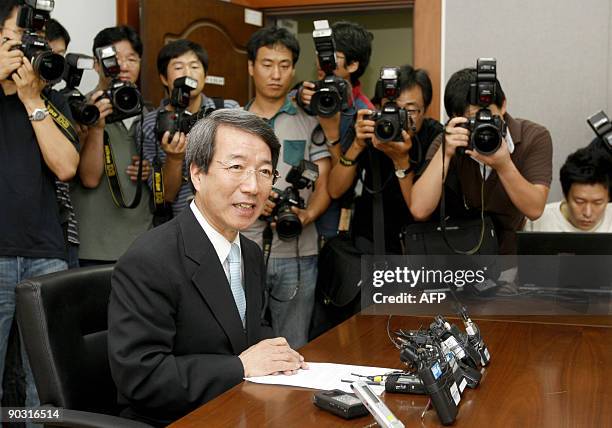 Photographers crowd around Chung Un-Chan, a professor of Seoul National University and former head of the university, as he speaks during a press...