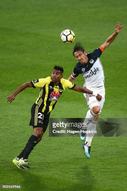 Mark Milligan of the Victory heads the ball under pressure from Roy Krishna of the Phoenix during the round 15 A-League match between the Wellington...