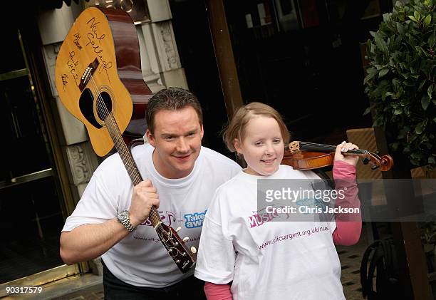 Opera Singer Russell Watson poses with cancer sufferer 18 year old Lizzy Davies for a photograph at a photocall to launch Practice-A-Thon at the Hard...
