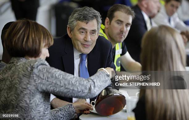 Britain's Prime Minister Gordon Brown speaks with workers and contractors in the canteen the Aquatic Centre construction site at the London 2012...