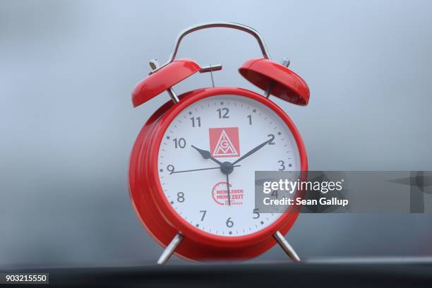 An alarm clock meant to symbolize the demand for workers to better determine their working hours stands near where workers from nearby Daimler and...