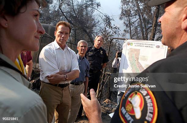 California Gov. Arnold Schwarzenegger is briefed on the status if the Station Fire after touring homes that were burned by the fire September 3, 2009...