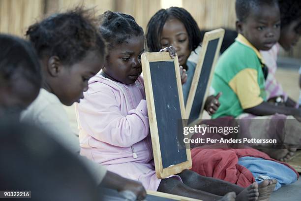 Children write on chalkboards during a class in a primary school on July 14 in Machalucuane, Mozambique. The village is located about 18 miles...