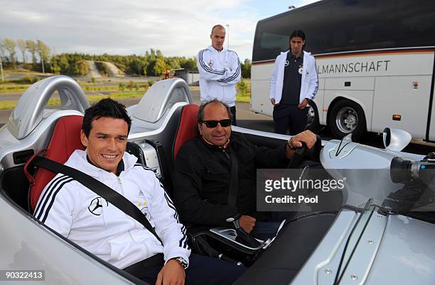 National player Piotr Trochowski, racing driver Klaus Ludwig, Robert Enke and Sami Khedira pose in front of the team bus and a Mercedes-Benz SLR...