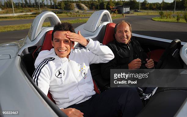 National player Piotr Trochowski and racing driver Klaus Ludwig pose inside a Mercedes-Benz SLR McLaren Stirling Moss during a safety training at the...