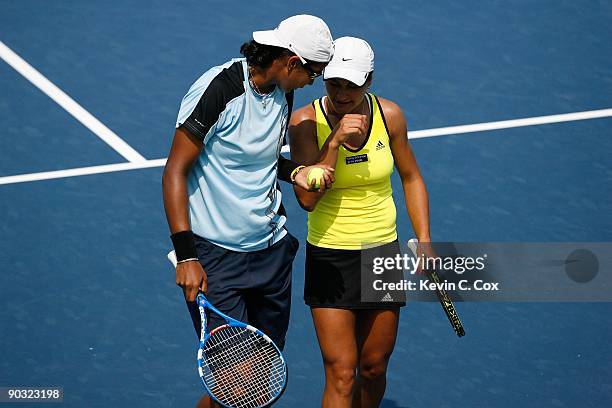 Akgul Amanmuradova of Uzbekistan and Monica Niculescu of Romania talk between points against Cara Black of Zimbabwe and Liezel Huber during the...