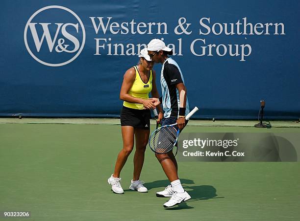 Akgul Amanmuradova of Uzbekistan and Monica Niculescu of Romania talk between points against Cara Black of Zimbabwe and Liezel Huber during the...