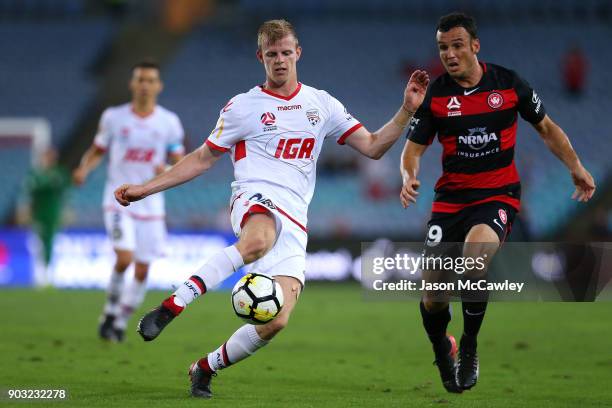 Jordan Elsey of Adelaide is challenged by Mark Bridge of the Wanderers during the round 15 A-League match between the Western Sydney Wanderers and...