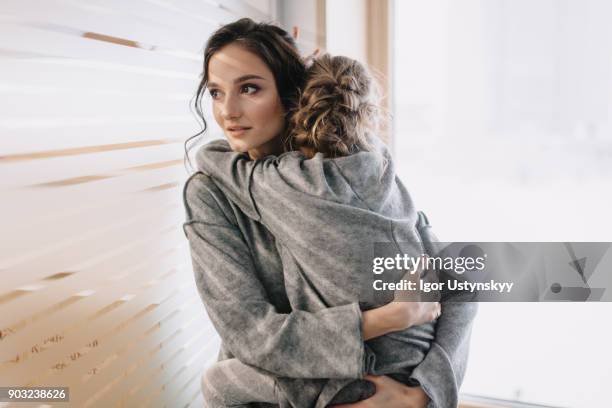 pretty young mother holding her lovely child - worried family stock pictures, royalty-free photos & images