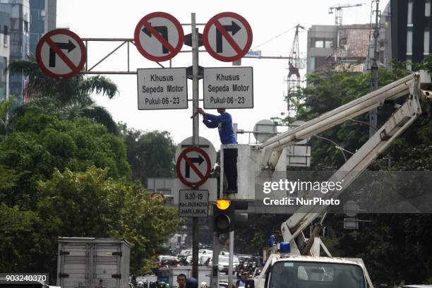 Jakarta Transportation Department officers dismantle traffic signs that prohibit two-wheeled vehicles passing on Jalan Mh. Thamrin, Central Jakarta,...