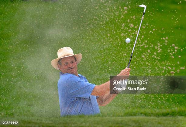 Sports announcer Chris Berman hits out of the bunker onto the 13th green during the Deutsche Bank Championship Pro-Am held at TPC Boston on September...