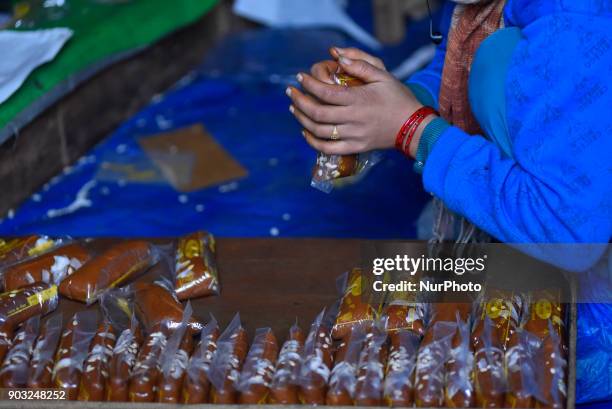 Worker packing molasses Chaku for sale at Tokha, Kathmandu, Nepal on Wednesday, January 10, 2018. Molasses Chaku is usually prepared and consumed...