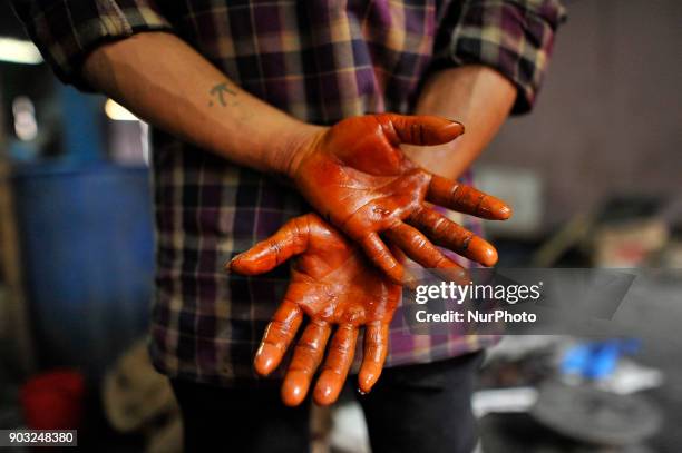 Hand of worker taking rest after whipping semi Hard molasses to prepare molasses Chaku at Tokha, Kathmandu, Nepal on Wednesday, January 10, 2018....