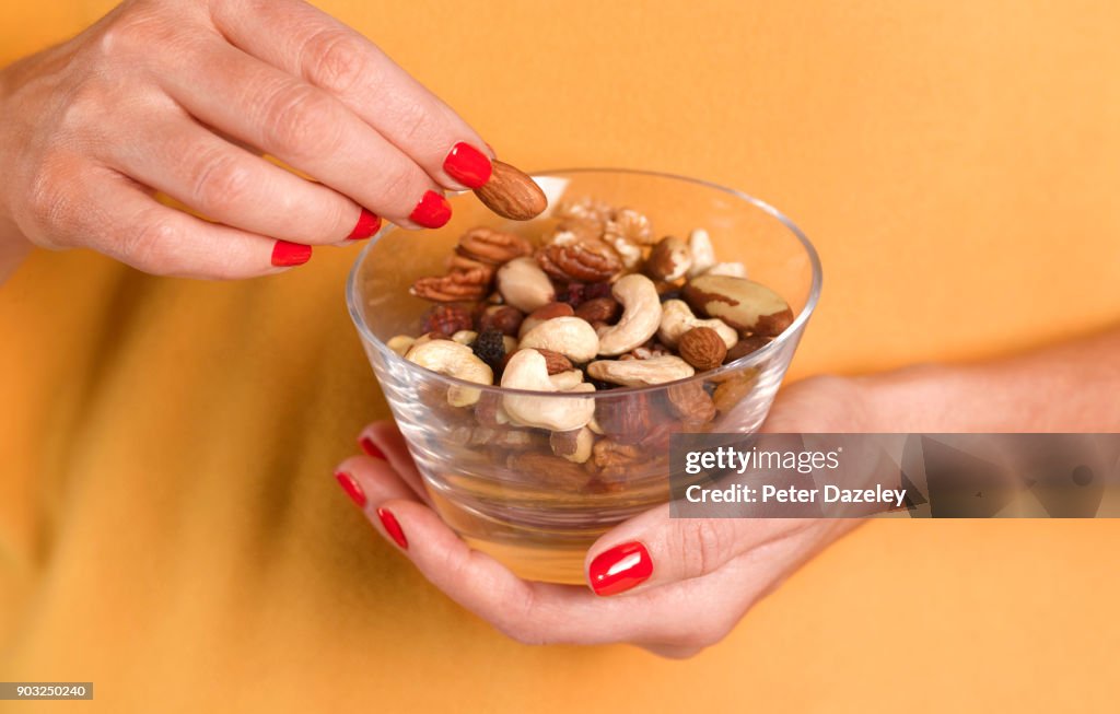 GIRL EATING NUTS FROM A BOWL
