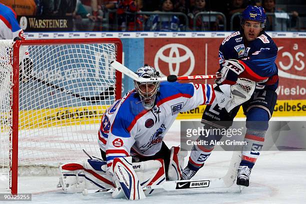 Goalkeeper Patrick Ehelechner of Nuernberg and Michael Hackert of Mannheim look after the puck during the DEL match between Adler Mannheim and Ice...