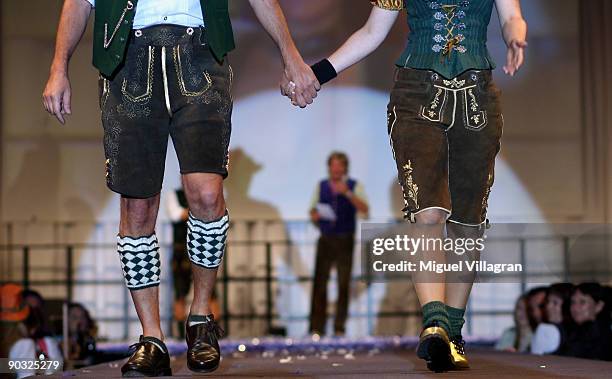 Dancers present Bavarian Lederhosen with golden applications during the Angermaier fashion show on September 3, 2009 in Munich, Germany.