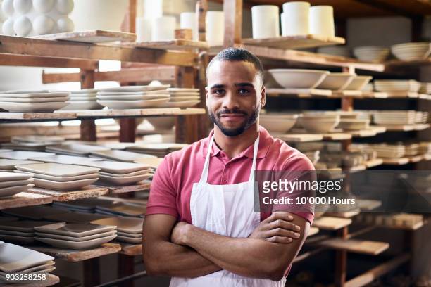 man in small pottery factory - man pottery stock pictures, royalty-free photos & images