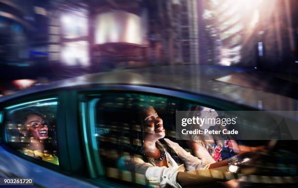 young women driving in car on night out - mode of transport stockfoto's en -beelden