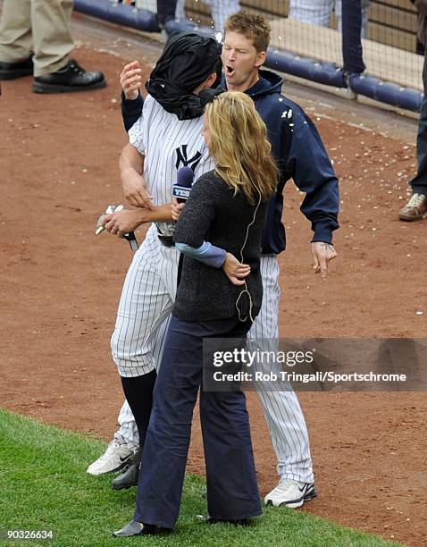 Johnny Damon of the New York Yankees gets a pie in the face by A.J. Burnett while being interviewed by Kim Jones after winning the game with a...