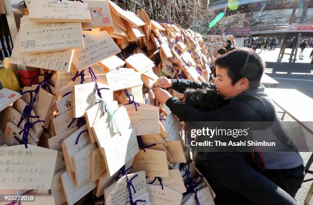 An elemenrary school students preparing for junior high school entrance exams places the 'Ema' wooden plaques in hopes of their success at Yushima...