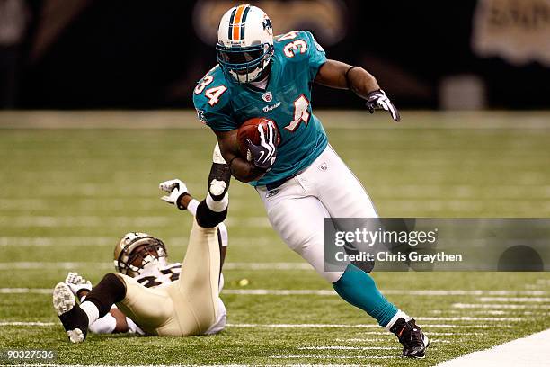 Ricky Williams of the Miami Dolphins avoids a tackle by Danny Gorrer of the New Orleans Saints at the Louisiana Superdome on September 3, 2009 in New...