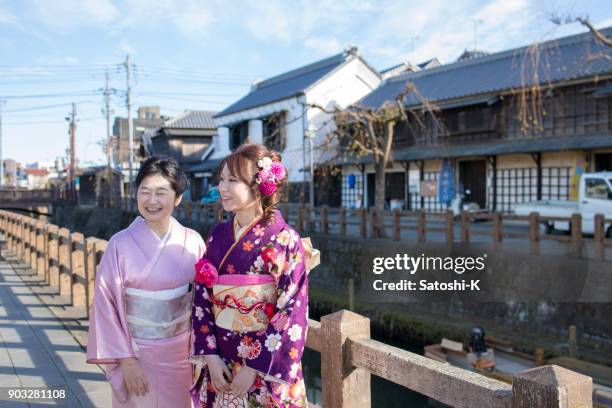 madre e hija en la ciudad japonesa tradicional en viniendo del día edad - seijin no hi fotografías e imágenes de stock