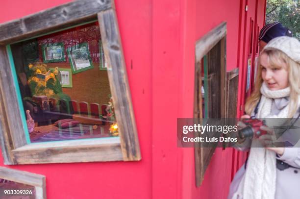 a young woman looks at a children´s life sized toy house with tedy bears. - s christmas festival stock pictures, royalty-free photos & images
