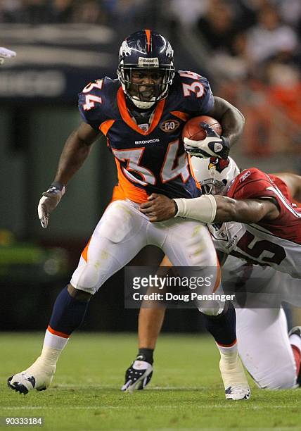 Running back Darius Walker of the Denver Broncos gains four yards tackled by line backer Ali Highsmith of the Arizona Cardinals during the NFL...