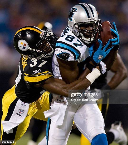 Muhsin Muhammad of the Carolina Panthers is wrapped up by Anthony Madison of the Pittsburgh Steelers during their preseason game at Bank of America...