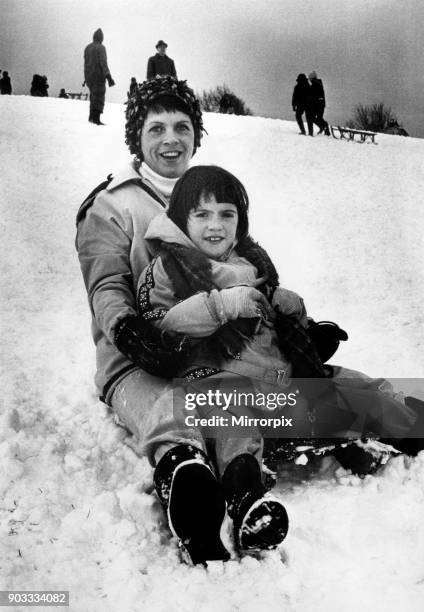 Sledges out at Ridgeway, Newport, south east Wales, 19th February 1978. Pictured, Jenny Hancock and her daughter Caroline sledge down hill.