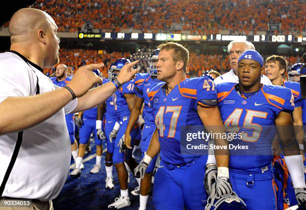 Boise State Bronco coach instructs players Dan Paul and Daron Mackey to get back after LaGarrette Blount of the Oregon Ducks punched a Boise State...
