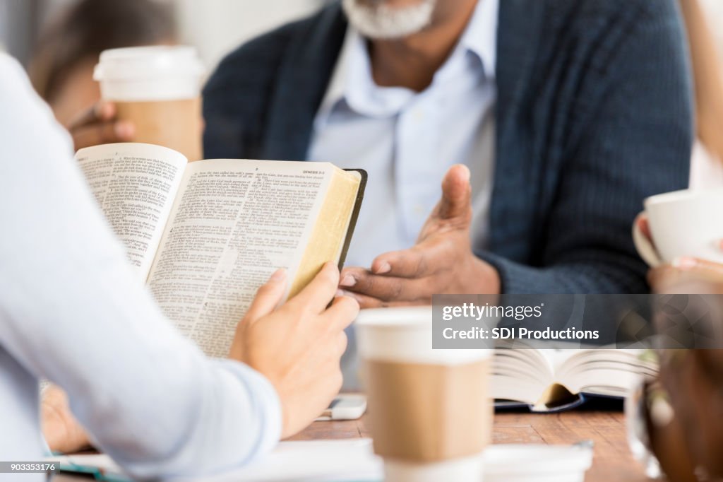 Unrecognizable people studying the Bible