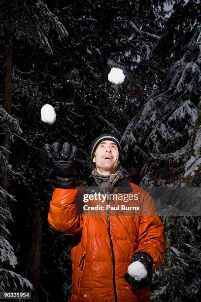 a man juggling snowballs in the snow - holding snowball stock pictures, royalty-free photos & images