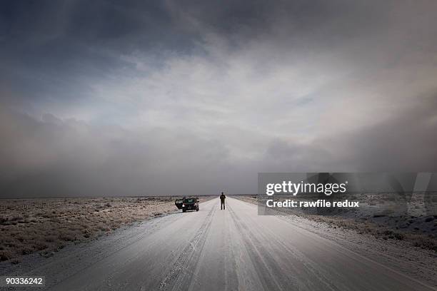 fixing your car on a remote wintery road - winter panne auto stock-fotos und bilder