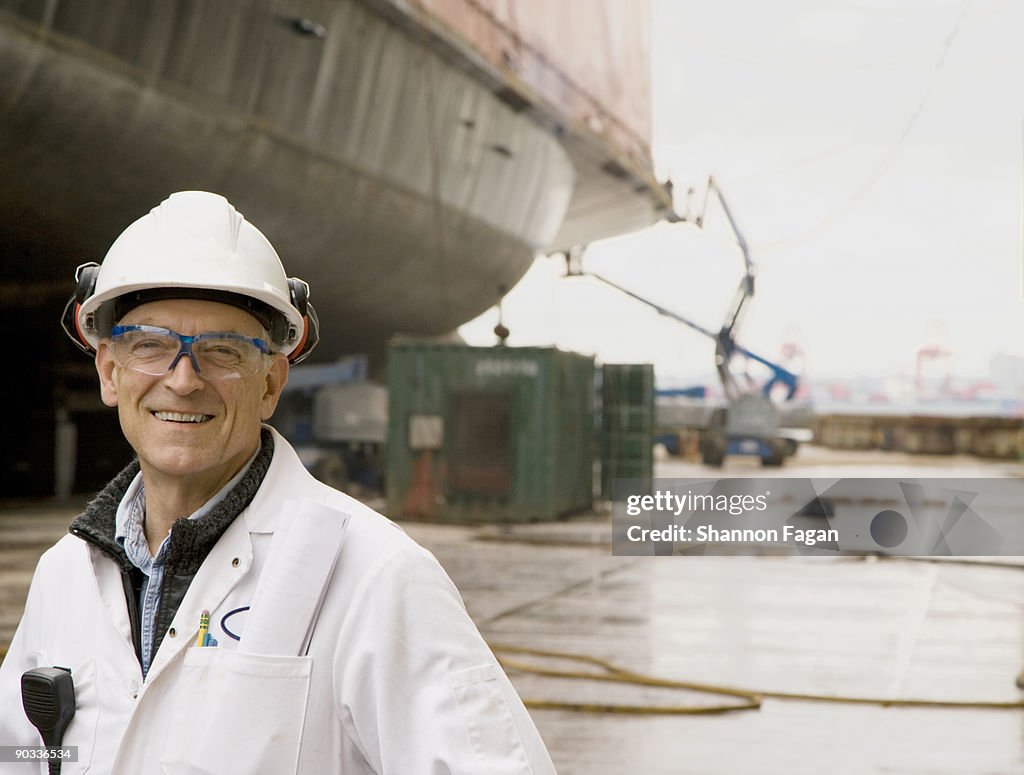 Man Wearing Hard Hat Standing in Shipyard
