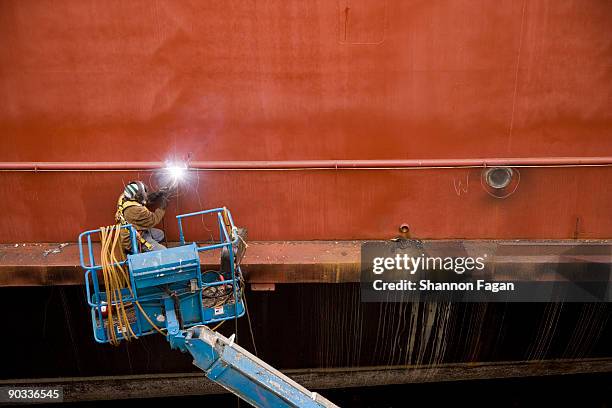 man welding side of ship - cherry picker stock pictures, royalty-free photos & images