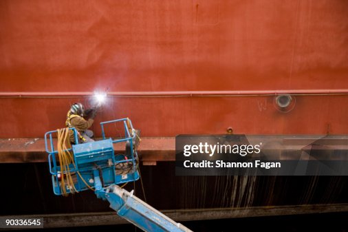 Man Welding Side of Ship Man Welding Side of Ship