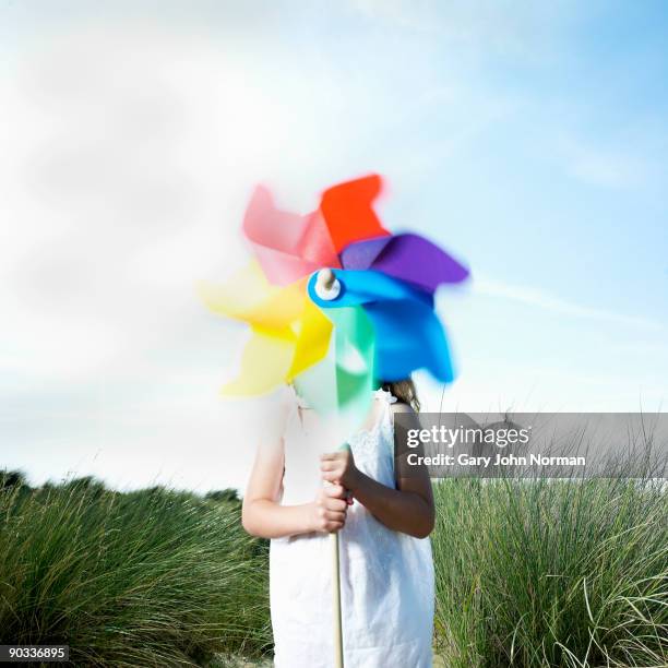 girl holding a pinwheel in sea grass & sand dunes - paper windmill bildbanksfoton och bilder