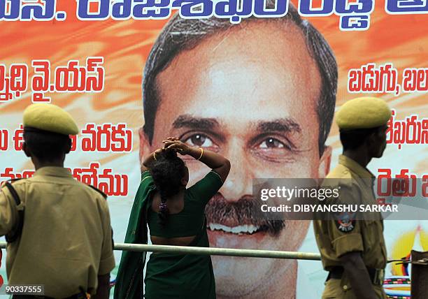 Supporter of deceased Indian Chief Minister of Andhra Pradesh Y S Rajasekhara Reddy breaks into tears in front of a poster of the chief minister at...