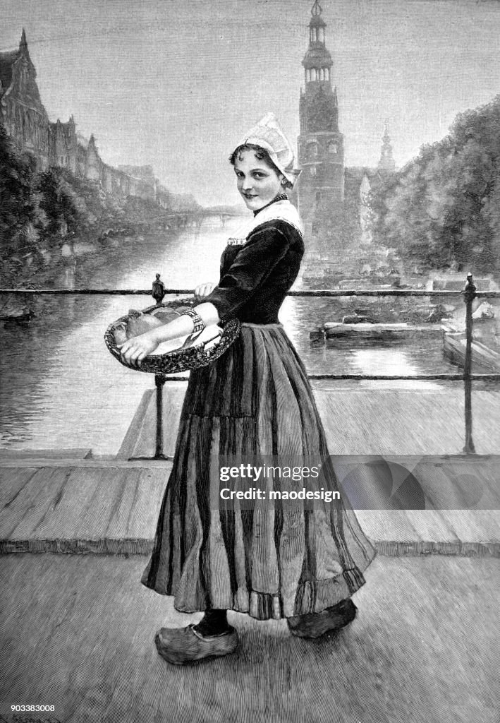 Young Dutch girl, wearing a traditional dress and a basket in his hands, stands on a bridge in Amsterdam - 1896